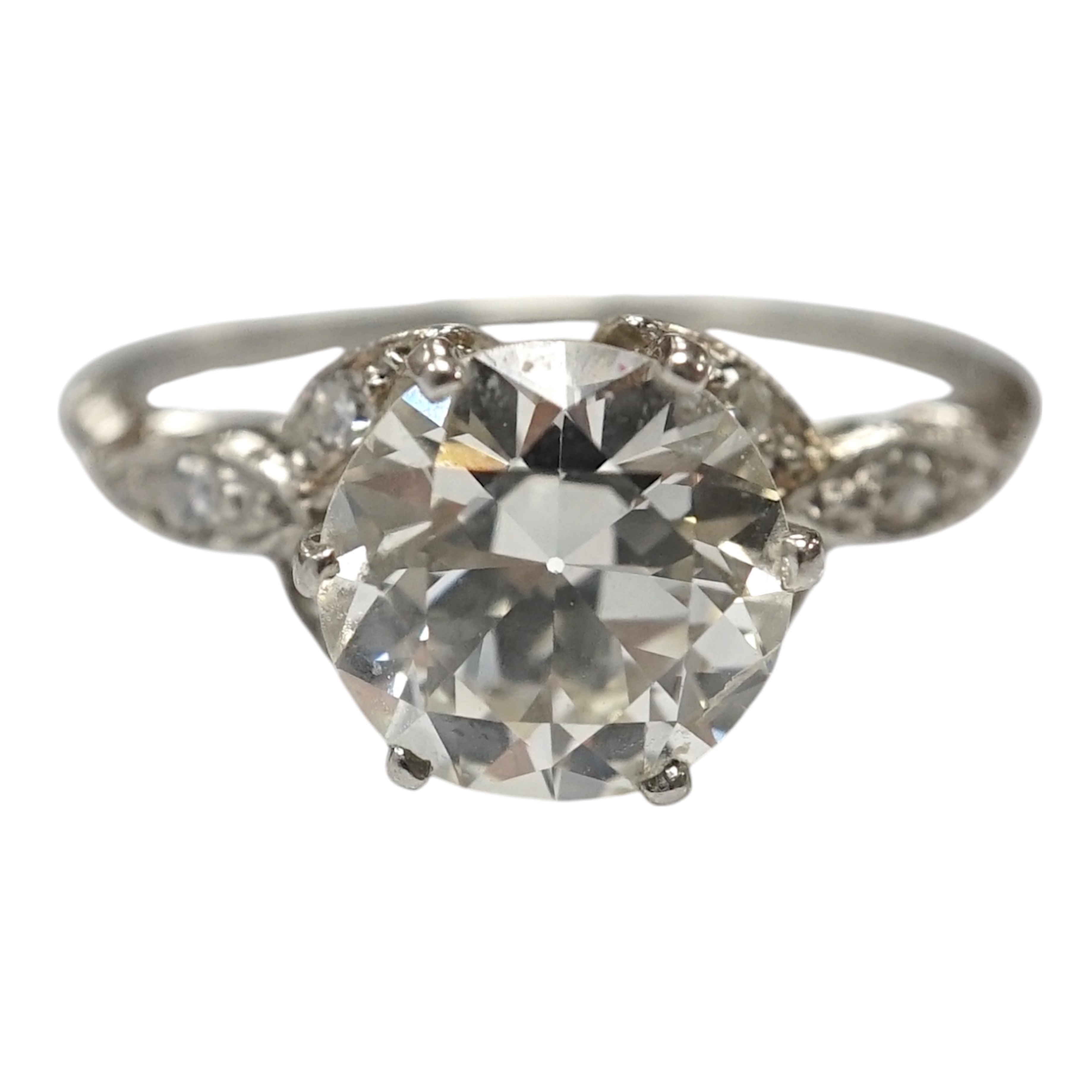 A platinum and single stone diamond set ring, with six stone diamond chip set foliate shoulders, the centre stone weighing 1.60ct, size H/I, gross weight 3.1 grams. Condition - fair